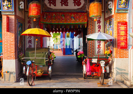 Tricycles pousse-pousse près de l'entrée de Temple de Hock Teik Cheng Sin, Armenian Street, Penang, Malaisie Banque D'Images