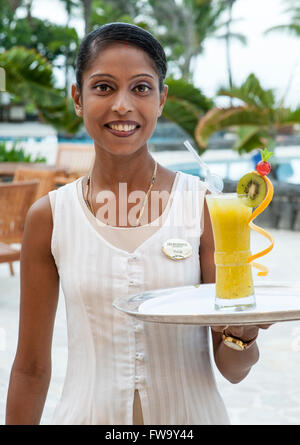 Serveuse avec un cocktail à la résidence hotel à Maurice. Banque D'Images