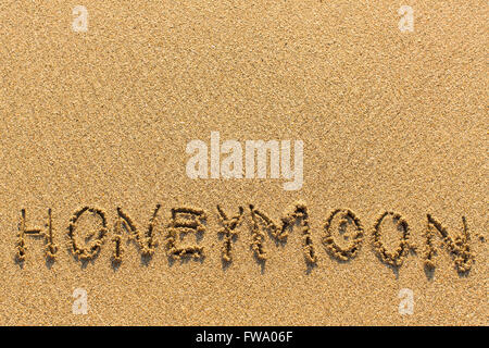 Miel - écrites manuellement sur la texture du sable de la mer. Banque D'Images