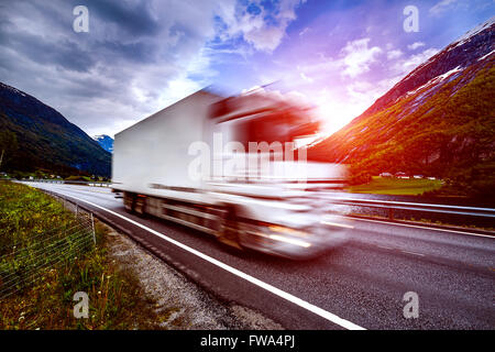 Camion et la route au coucher du soleil. Location de camion à l'effet de flou. Banque D'Images