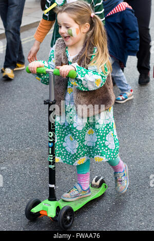 Petite fille sur un scooter habillé pour la traditionnelle parade de la St Patrick à Londres en Angleterre Banque D'Images