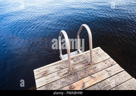 L'eau d'un bleu profond et jetée en bois pour la baignade sur la côte du lac encore Banque D'Images