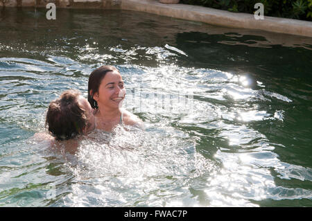 Jeune couple en vacances à jouer dans une piscine Banque D'Images