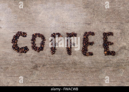 Café Inscription fabriqués à partir de fèves grillées disposés sur la texture en bois Banque D'Images