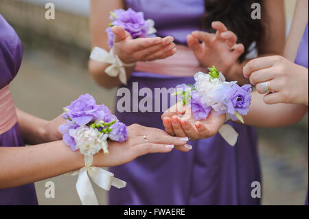 Robes de demoiselle d'honneur en violet. Close up de demoiselles avec mains bouquet coloré. Banque D'Images