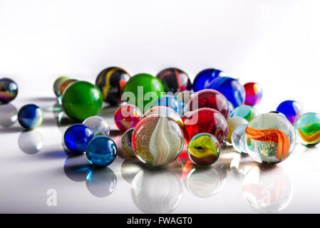 Groupe de billes mixtes sur une surface blanche réfléchissante Banque D'Images