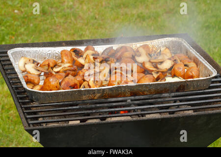 Barbecue avec une poêle, rempli de champignons et oignons Banque D'Images