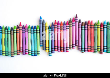 Crayons et pastels alignés dans rainbow isolé sur fond blanc Banque D'Images