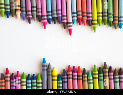 Crayons et pastels alignés dans rainbow isolé sur fond blanc Banque D'Images