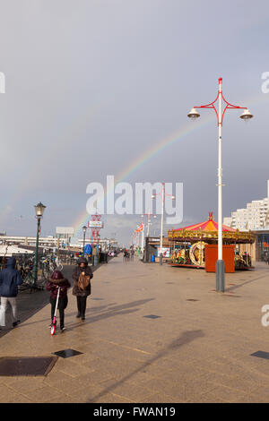 Les gens marchent sous ciel gris et arc-en-ciel sur le boulevard de Scheveningen en Hollande Banque D'Images