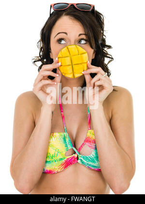 Santé de la jeune femme tenant un morceau de mangue fruits isolés sur un fond blanc. Banque D'Images