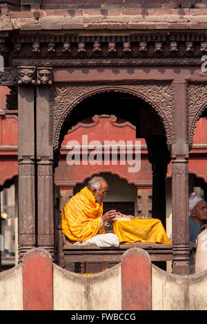 Pashupatinath, Népal. Sadhu, un ascète hindou ou saint homme, la lecture de textes sacrés dans le Temple. Banque D'Images