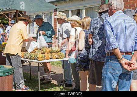 Les gens faisant la queue pour acheter des ananas à Nundle les marchés en plein air,NSW Australie Banque D'Images