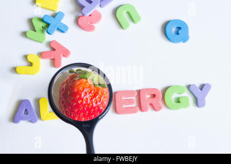 Allergie alimentaire concept de fraise avec des lettres et la loupe closeup Banque D'Images