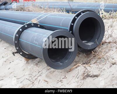 Tuyaux en plastique sur fond de sable Banque D'Images