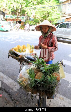 Dame vietnamienne fruits frais de vente de son vélo dans le vieux quartier de Hanoi, Vietnam, Asie Banque D'Images