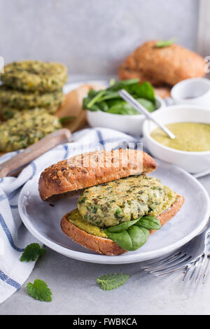 Burger végétarien délicieux servi avec du pesto vert et d'épinards frais Banque D'Images