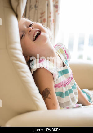 Jeune fille sur une chaise de rire Banque D'Images
