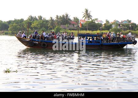 Ferry surchargé de motos crossing river, Hoi An, Vietnam, Asie Banque D'Images