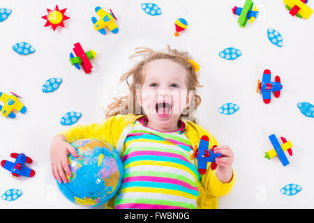 Enfant jouant avec des avions. Enfant d'âge préscolaire voler autour du monde. Les enfants qui voyagent et jouer. Banque D'Images