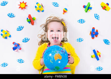 Enfant jouant avec des avions. Enfant d'âge préscolaire voler autour du monde. Les enfants qui voyagent et jouer. Banque D'Images