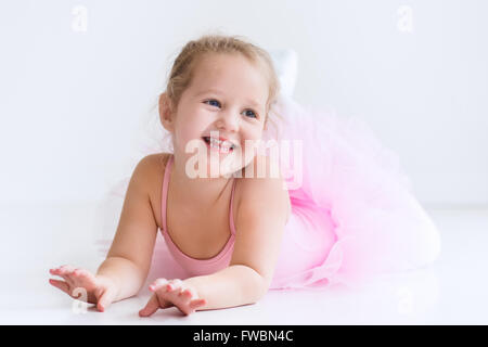 Petite fille ballerine dans un tutu rose. Adorable enfant danse ballet classique dans un livre blanc studio. Les enfants de la danse. Banque D'Images