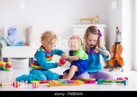 Les enfants avec des instruments de musique. L'éducation musicale pour les enfants. Art toys en bois coloré. Petite fille et garçon de jouer de la musique. Banque D'Images