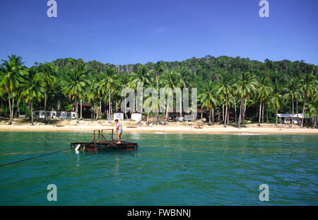 Sibu island au large de la Malaisie et les décideurs ont besoin de vacances à bord d'un petit radeau à partir de leur bateau et sont ensuite tiré sur le radeau par corde à travers l'île. L'île a un style chalet / hut resort et est typique des petites îles de la région offrant calme solitaire se casse sur la magnifique bordée de palmiers des plages de sable. Banque D'Images