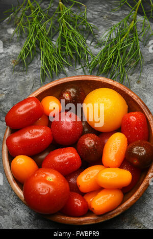 Vue de dessus d'un bol de tomates fraîches cueillies Medley sur une surface en ardoise. Format vertical. Banque D'Images