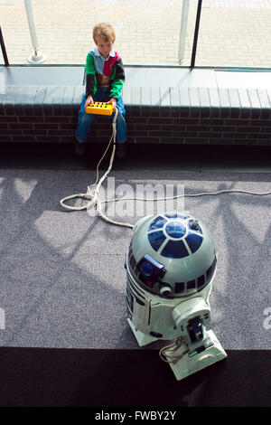 Les petits enfants palying à ascience centre avec un modèle de robot R2D2 le personnage de la série de films Star Wars. Banque D'Images