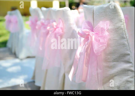 Belles chaises avec arcs rose lors de la cérémonie du mariage Banque D'Images