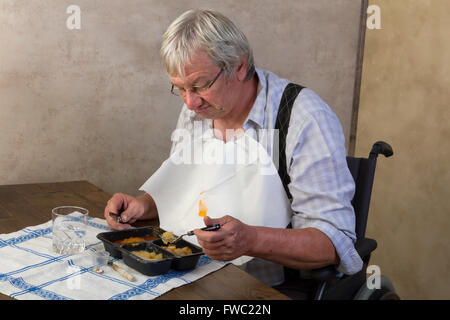 Un homme âgé en foyer de l'amour et son dîner prêt à l'emploi Banque D'Images