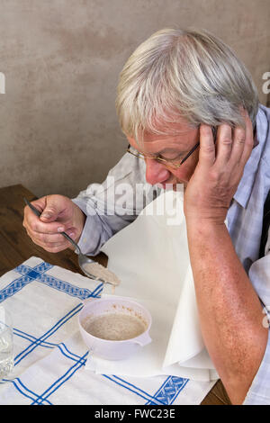 Vieil homme solitaire détestant son porridge petit déjeuner le matin Banque D'Images