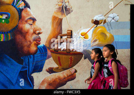 Deux rif marcher devant un mur haletant dans San Juan La Laguna, Solola, Guatemala. Peinture art traditionnels mayas à Santiago Banque D'Images