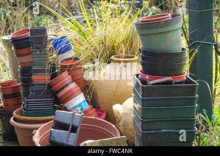 Des piles de plastique et pots de terre cuite à l'extérieur dans un jardin. Banque D'Images