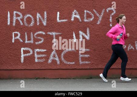 Un jogger passe devant le graffiti qui lit "Dame de fer ? La rouille de la paix" se référant à l'ancien premier ministre britannique Margaret Thatcher dans l'ouest de Belfast, Irlande du Nord, le 9 avril, 2013 un jour après la mort de Thatcher. La Grande-Bretagne s'est profondément divisé sur l'héritage de l'ancien premier ministre Margaret Thatcher qu'il fait des préparatifs pour le grand enterrement la semaine prochaine de la femme connue dans le monde entier comme la "Dame de fer". Banque D'Images