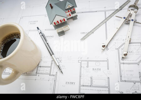 Maison modèle, tasse de café, crayon, règle et compas reposant sur des plans de maison. Banque D'Images