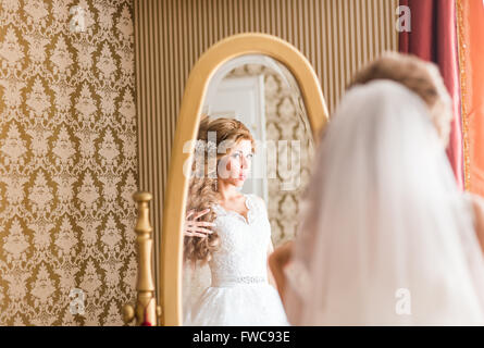 Jeune femme se regarde dans le miroir Banque D'Images