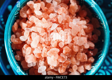 Les cristaux de sel rose de l'himalaya Close Up dans un bol en céramique bleu font foi. Vue de dessus, Selective Focus. L'espace pour le texte. Banque D'Images