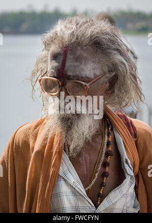 Mumbai, Inde - le 15 octobre 2013 : vieux sadhu grisonnants, avec barbe et lunettes. Porte des vêtements orange. Banque D'Images