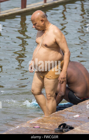 Mumbai, Inde - le 15 octobre 2013 : Un homme obèse descend dans le fleuve Cauvery pour son bain rituel. Banque D'Images