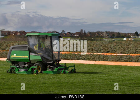 Entretien hippodrome Liverpool, Merseyside, UK Préparatifs en cours pour le Grand National Aintree. Les entrepreneurs, à l'aide d'un John Deere série 1600 turbo ii, sont occupés à l'emplacement qui met actuellement la touche finale à l'événement de course de chevaux qui commence jeudi jusqu'à ce qu'est la plus grande course de chevaux le samedi après-midi. Banque D'Images