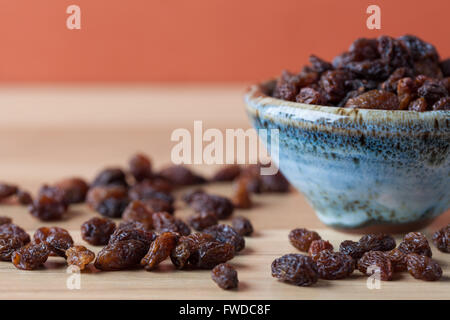 Raisins biologiques dans Bol en céramique faite à la main sur table en bois. Image horizontale à l'exemplaire de l'espace. Profondeur de champ. Banque D'Images