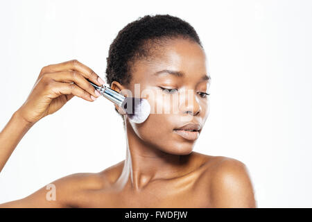 South American Woman applying makeup avec brosse isolé sur fond blanc Banque D'Images