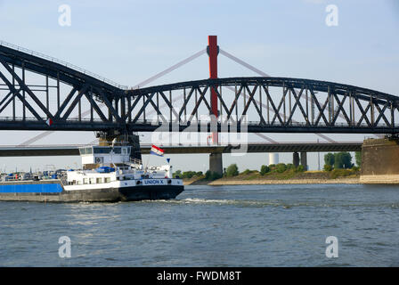 Une péniche passe sous un pont sur le Rhin près de Arnhem, Pays-Bas Banque D'Images