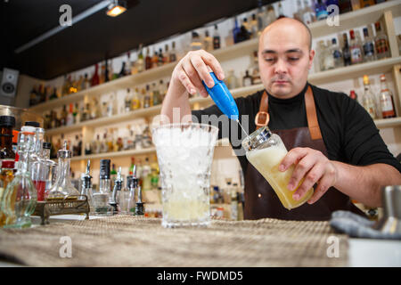 Barman à l'aide d'un batteur électrique pour préparer des boissons au bar ou au pub Banque D'Images