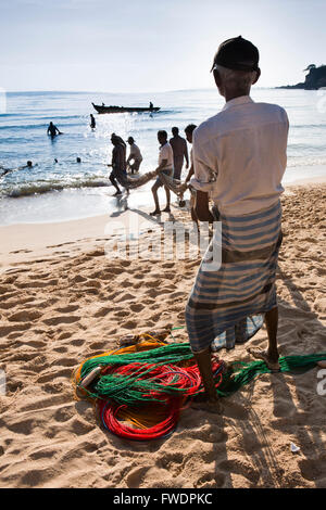 Sri Lanka, Trincomalee, Dutch Bay hommes musulmans, relève des filets de horseshoe à partir de la rive Banque D'Images