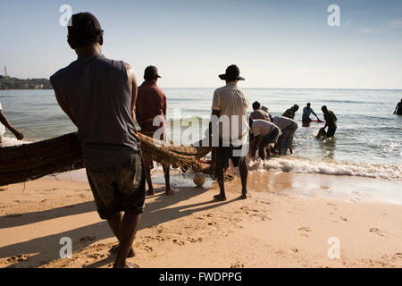 Sri Lanka, Trincomalee, Dutch Bay, les pêcheurs en filets de pêche transportant horseshoe à partir de la rive Banque D'Images