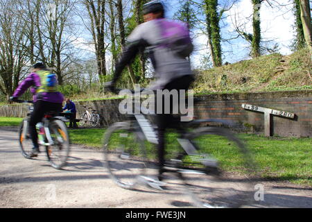 Cyclistes sur la piste de Tissington à la recherche d'un indicateur de pente sur cette ancienne ligne ferroviaire mis à pied et à vélo, allée cavalière, UK Banque D'Images