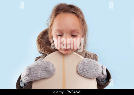 Petite fille mignonne avec snowboard. L'hiver. Banque D'Images